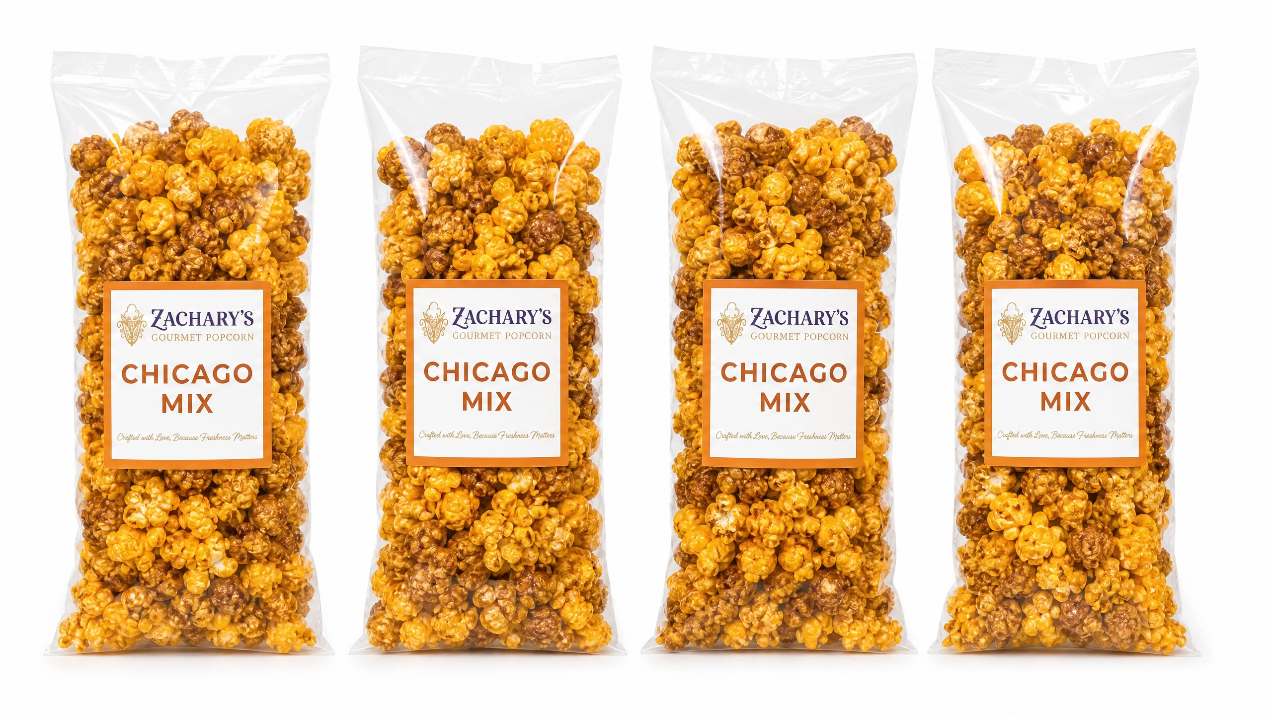 Four bags of Zachary's Chicago Mix gourmet popcorn in a row, caramel and cheddar kernel blend in resealable bags with orange and white label