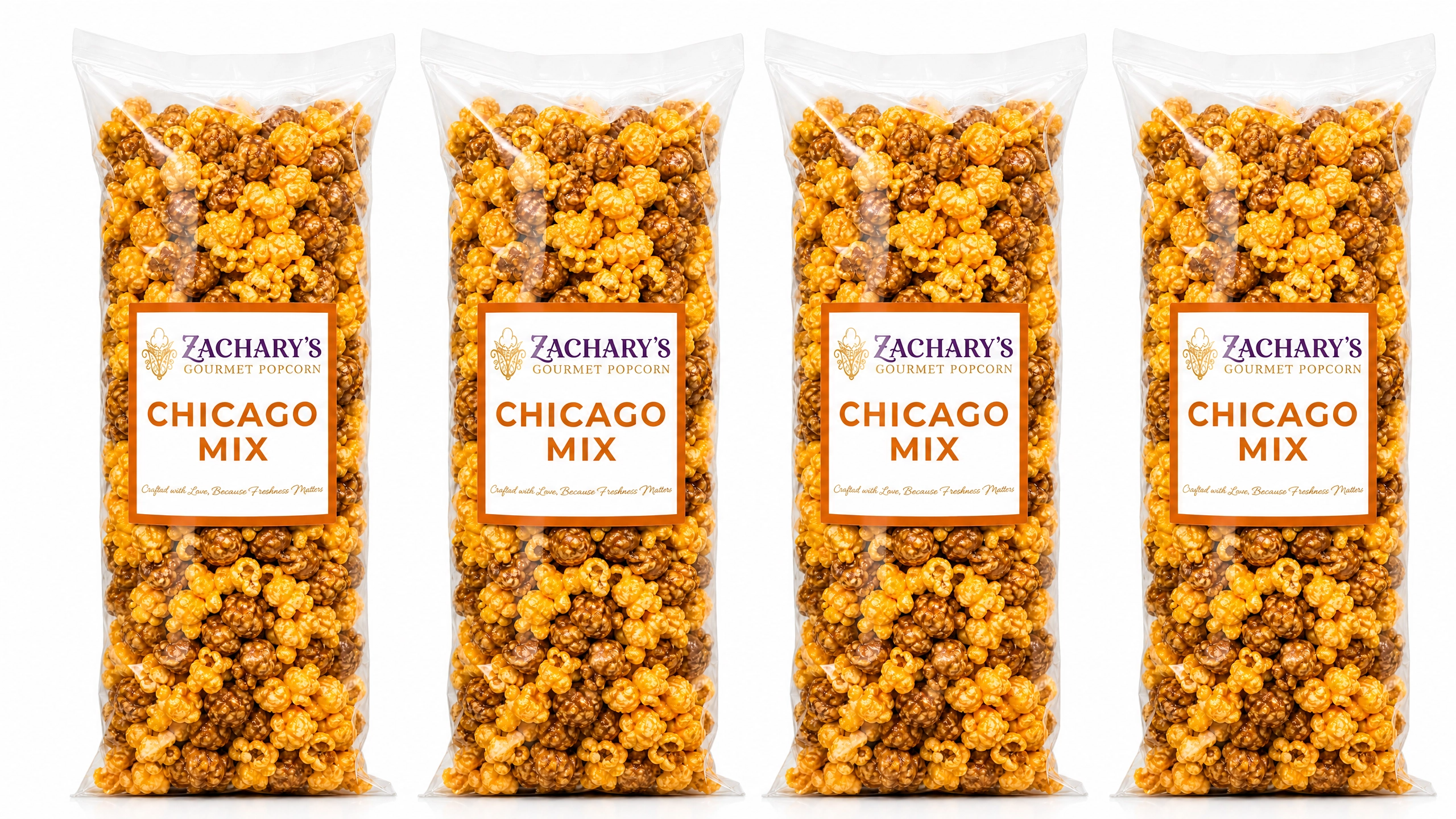 Four large party-size bags of Zachary's Chicago Mix gourmet popcorn in a row, caramel and cheddar kernel blend with orange and white label