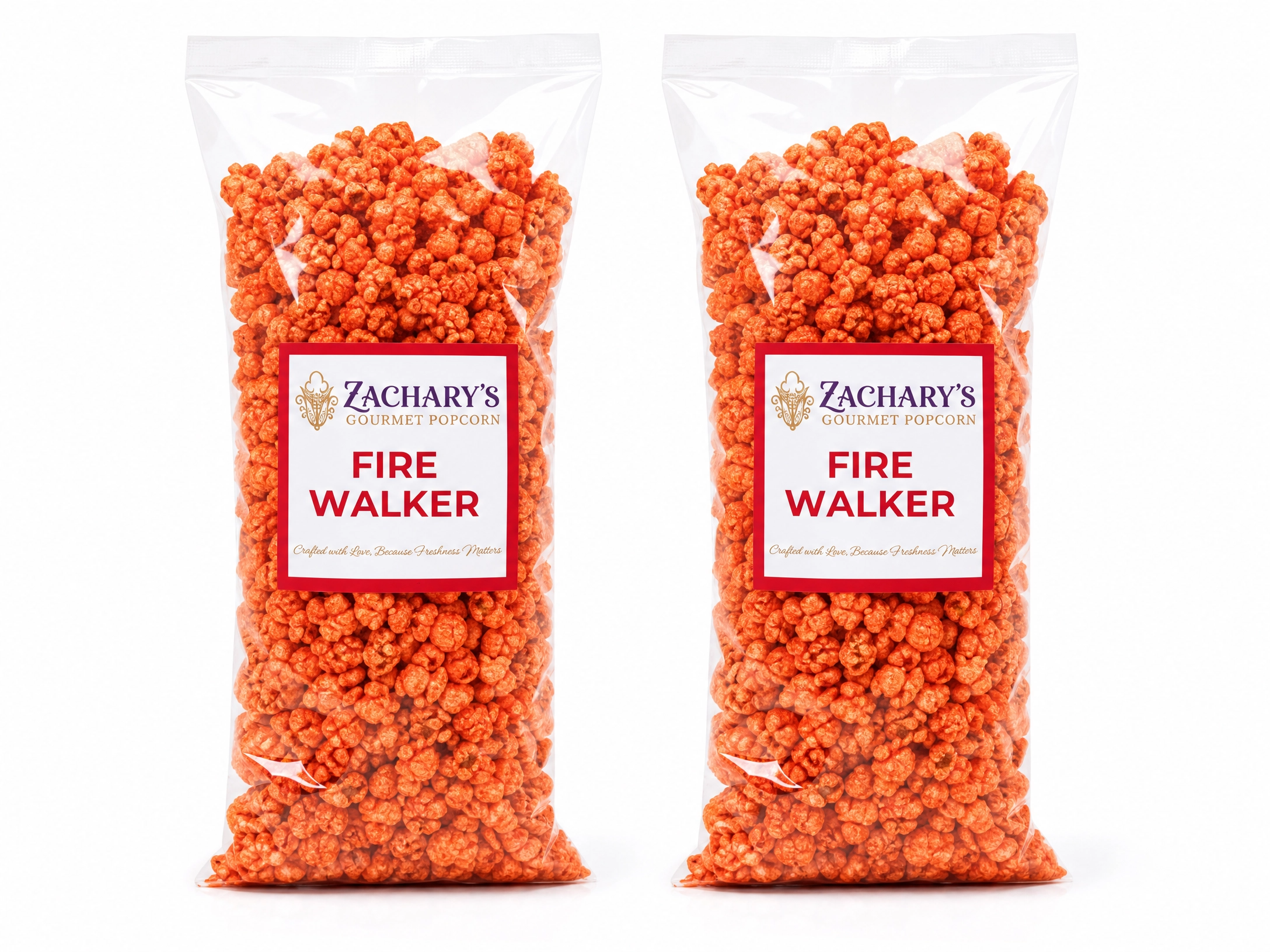 2 Bags of Zachary's Fire Walker gourmet popcorn, bright orange spicy-coated kernels in a clear bag with red and white label

