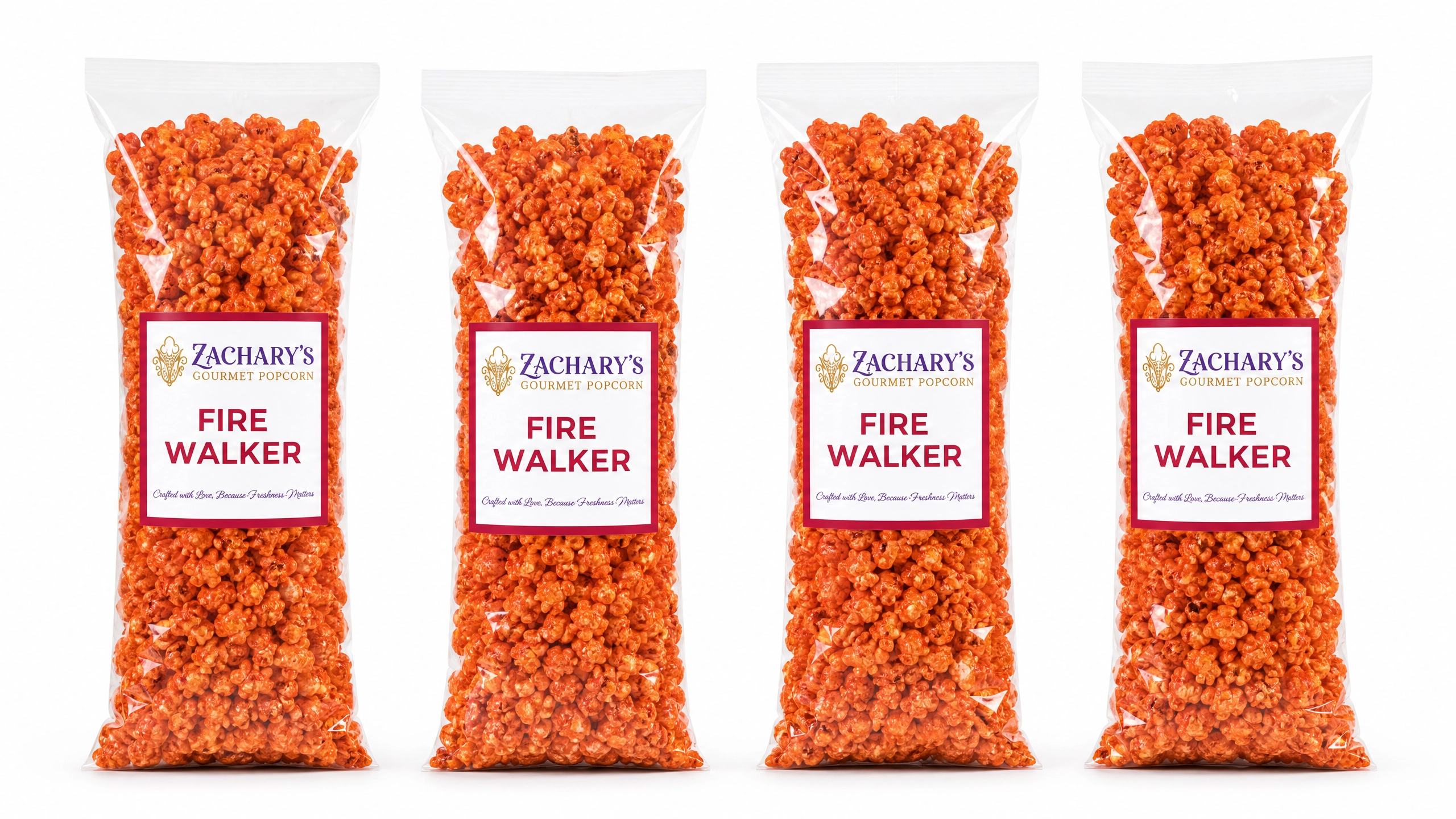 Four bags of Zachary's Fire Walker gourmet popcorn in a row, orange spicy-coated kernels in clear bags with red and white labels