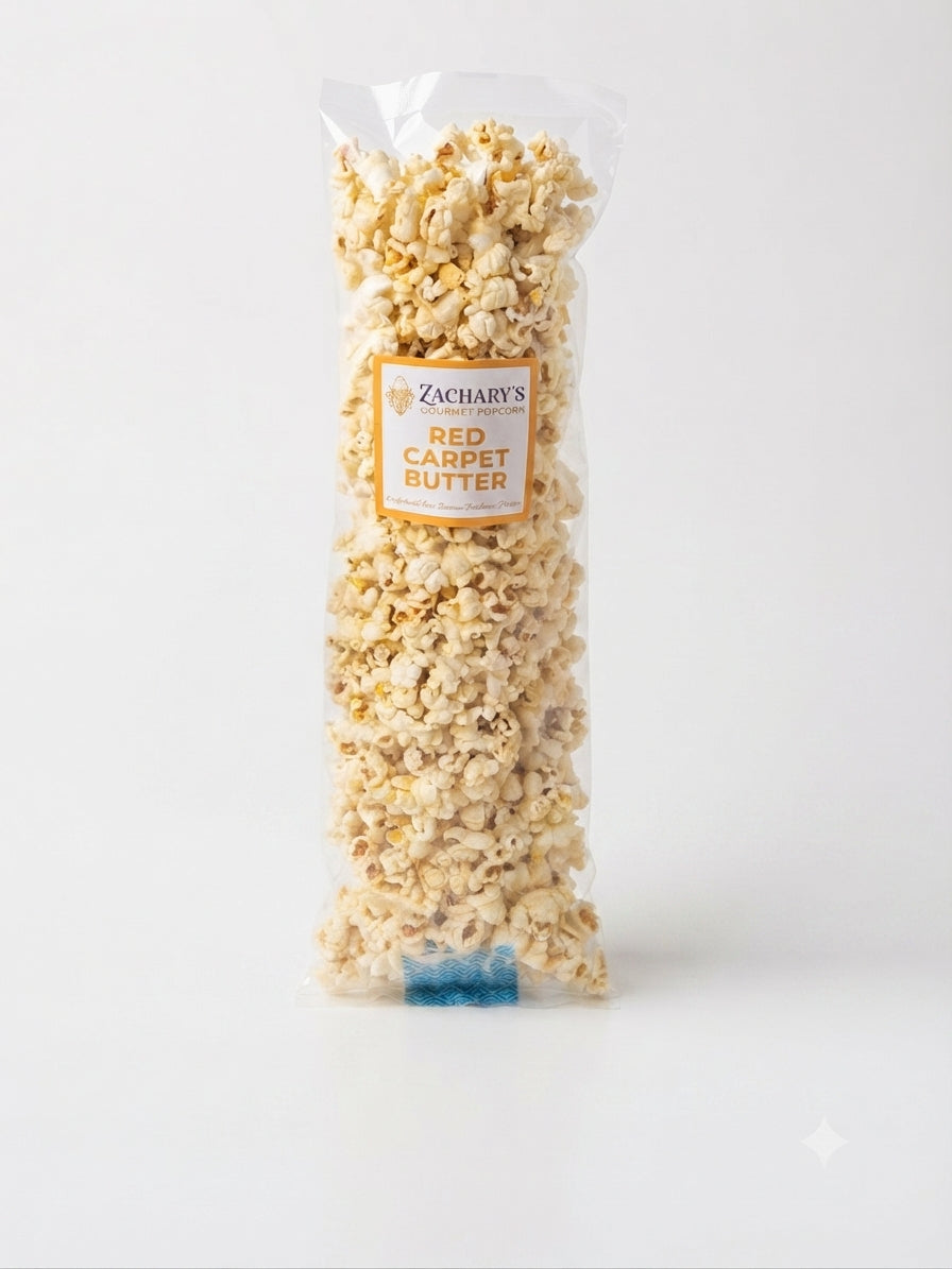A clear plastic bag filled with popcorn and topped with a label reading 'Zachary's Red Carpet Butter' on a light gray background.