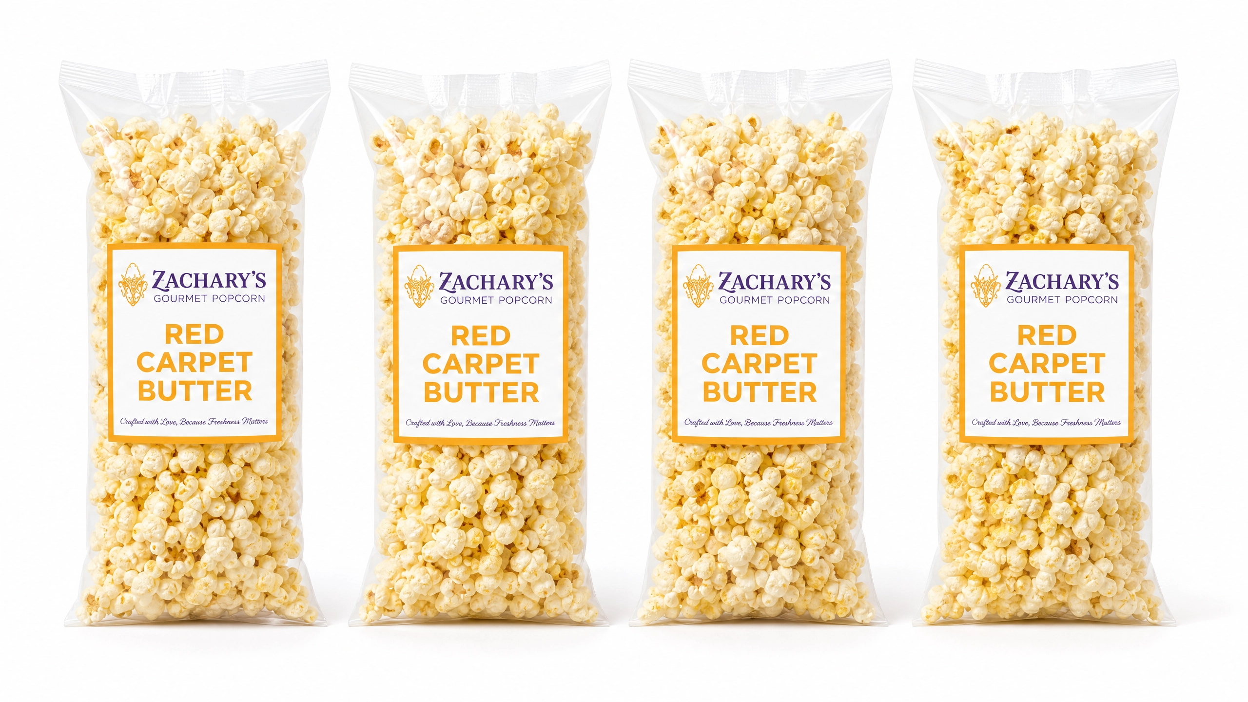 Four bags of Zachary's Red Carpet Butter gourmet popcorn in a row, classic golden buttery kernels in resealable bags with gold and white label