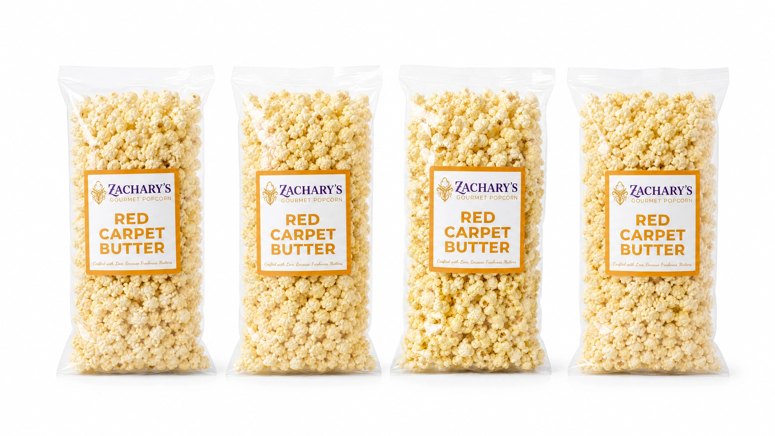 Four bags of Zachary's Red Carpet Butter gourmet popcorn in a row, classic golden buttery kernels in resealable bags with gold and white label