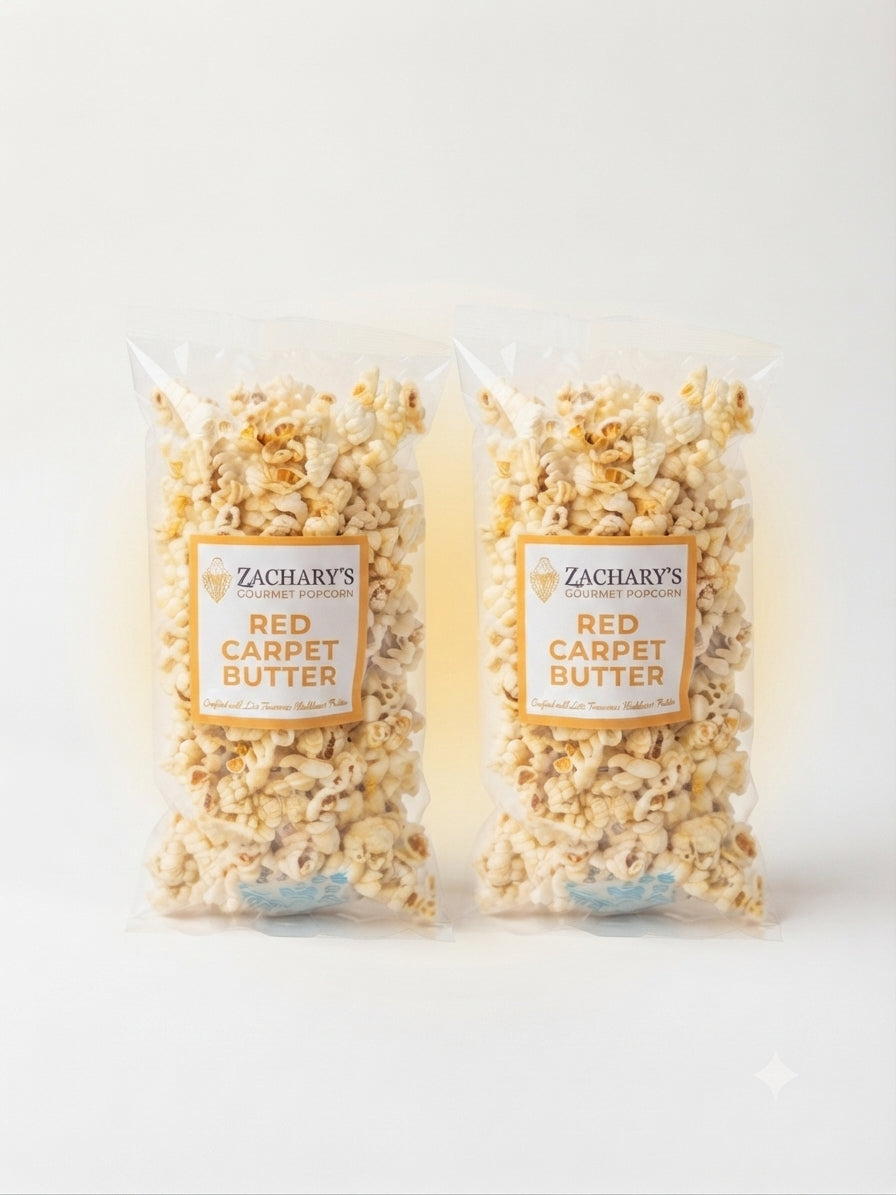Two clear plastic bags of Zachary's Gourmet Red Carpet Butter popcorn, showing the buttered popcorn inside, set against a clean white background.